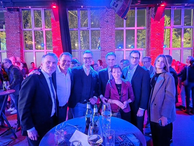 Lossprechung 2026 2 Zwei Personen auf der Bühne der Elektro-Innung Düsseldorf halten eine Abschlussurkunde in die Kamera und lächeln, im Hintergrund ist eine Präsentationsfolie zu sehen.